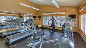 A gym with treadmills, elliptical machines, and weight equipment.