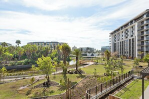 A residential area with modern buildings, a landscaped garden with trees, and a small water feature. - Park Place, Elegant Retreat with Lake Views (Cape Town)
