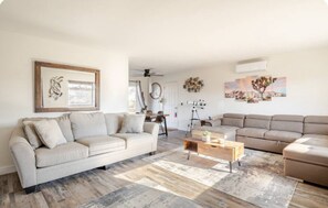 A living room with a sofa, a coffee table, and a telescope.