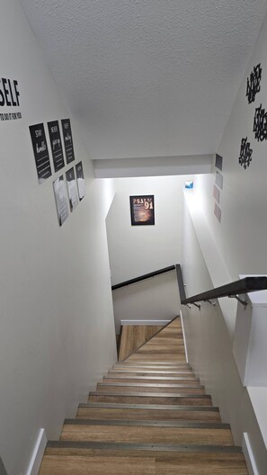 A staircase with wooden steps and metal handrails, leading to a landing with a framed inspirational quote. - Room-cozy 2BR Suite in Saskatoon East (Saskatoon)