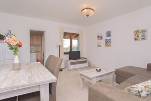 A living room with a dining table, sofa, TV stand, and artwork on the wall. - Holiday home for 6 people with private pool, barbecue  Wi-Fi, air conditioning (Santanyí)