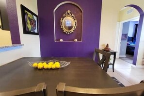 Ein Essbereich mit Tisch und Stühlen, eine dekorative Wand mit einer Plakette und ein Durchgang zu einem anderen Raum.