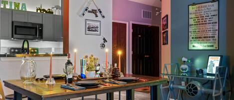 A modern kitchen with a microwave, cabinets, and a dining area with a table set for two.