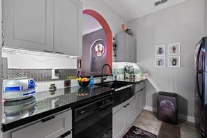 Eine moderne Küche mit schwarzem Arbeitsplatz, weißen Schränken und einer Wand im Stil von Star Wars.