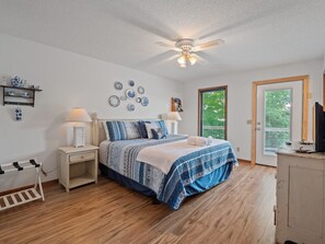 A bedroom with a bed, bedside tables, a ceiling fan, a window, and a door. - Decked Out in Dismal - Decks and Amenities! (Arley)