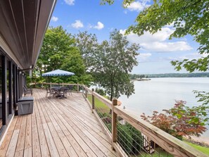 A wooden deck with outdoor furniture and a view of a lake. - Decked Out in Dismal - Decks and Amenities! (Arley)