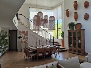 A spacious dining area with a high ceiling, a staircase, and a view of the outdoors. - Your Dream Family or Group Getaway: 5 Bedroom Luxury Villa Awaits in Cofresi! (Cofresi)