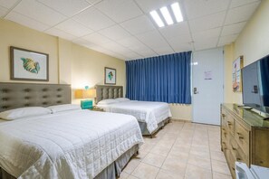 A hotel room with two beds, a dresser, a television, and artwork on the walls. - Your Dream Family or Group Getaway: 5 Bedroom Luxury Villa Awaits in Cofresi! (Cofresi)