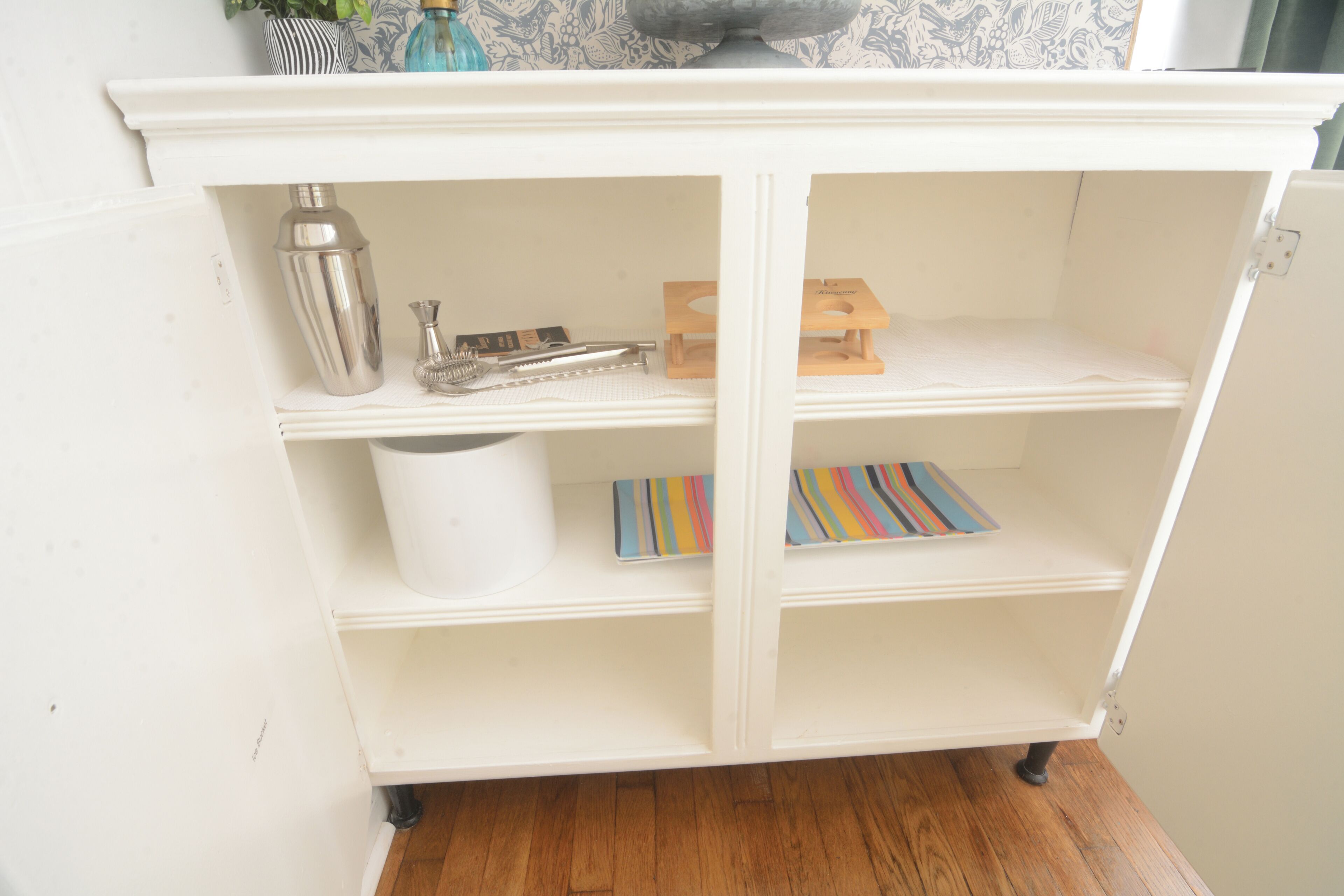 A white cabinet with shelves containing various items.