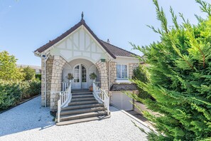 Ein traditionelles Gebäude mit einer Stein-Fassade, einem Satteldach und einer Treppe, die zum Eingang führt.