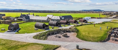 A rural property with multiple buildings, a golf course, and a parking area.