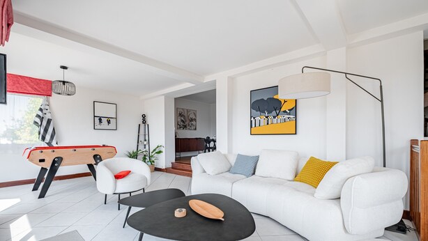 Ein modernes Wohnzimmer mit einer Couch, einem Couchtisch und einem Billardtisch.