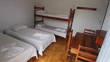 Ett sovsalsrum med våningssängar, ett träbord och stolar.