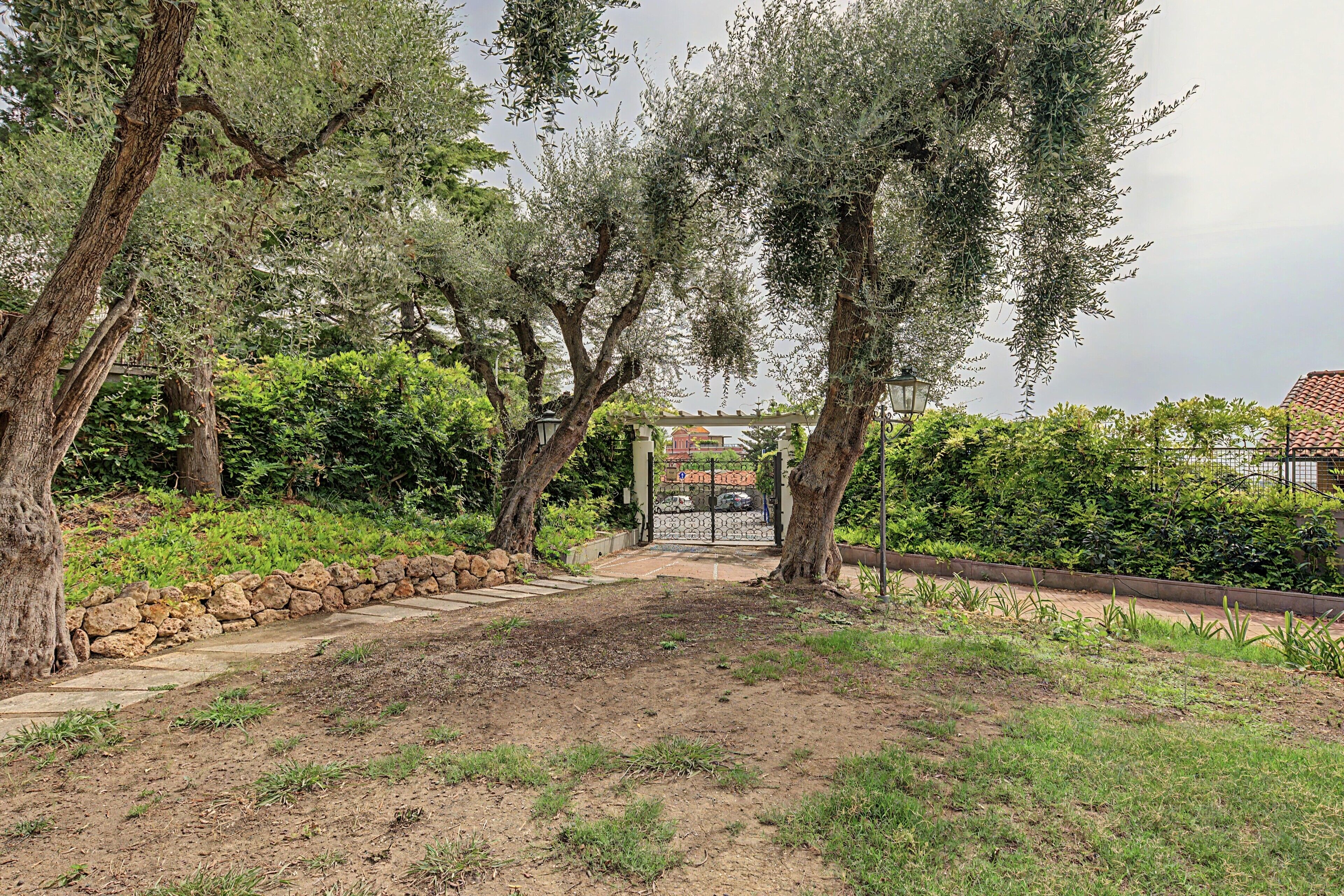 Un sentier de jardin qui mène à une pergola d’où l’on peut admirer un quartier résidentiel.