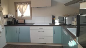 A kitchen with a toaster, microwave, and a refrigerator. - Charming, fully equipped apartment in a chalet for a couple, with a panoramic view (sallanches)