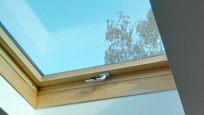 A room with a skylight, a bed, a small table with a plant, and two paintings on the walls. - Charming, fully equipped apartment in a chalet for a couple, with a panoramic view (sallanches)