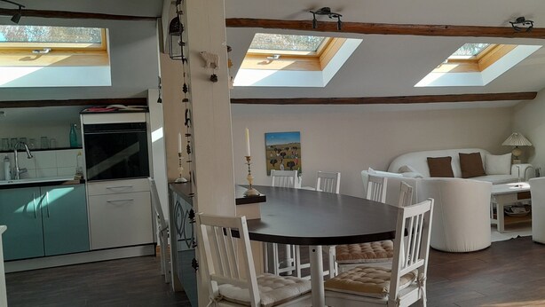 A modern interior with a dining area, kitchen, and seating space. - Charming, fully equipped apartment in a chalet for a couple, with a panoramic view (sallanches)