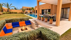 Une terrasse extérieure moderne, dotée d’une piscine, d’un espace salon et d’un foyer.