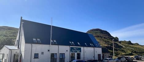 A building named 'The Quay House' with a parking lot and cars.