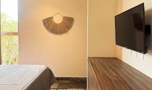 A room with a bed, a wall-mounted TV, and a decorative wall hanging. - Luxury 3BR Tulum Penthouse with Private Pool (Tulum)