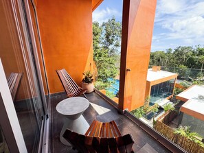 A balcony with a wooden bench, a round table, and a potted plant. - Luxury 3BR Tulum Penthouse with Private Pool (Tulum)
