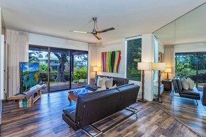 A modern living room with a black sofa, a coffee table, and a ceiling fan. - Wailea Ekahi Village 3A - Townhome Near Keawakapu Beach (WAILEA)