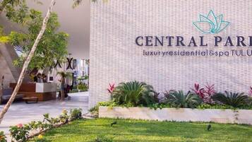 A reception area with a modern design, a logo, and a landscaped garden.