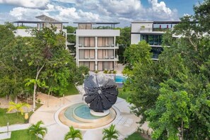 Un hôtel moderne doté d’une cour intérieure, d’un grand espace aquatique et d’une végétation luxuriante.