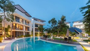 Un hotel moderno con piscina, zona de estar al aire libre y jardín bien cuidado.