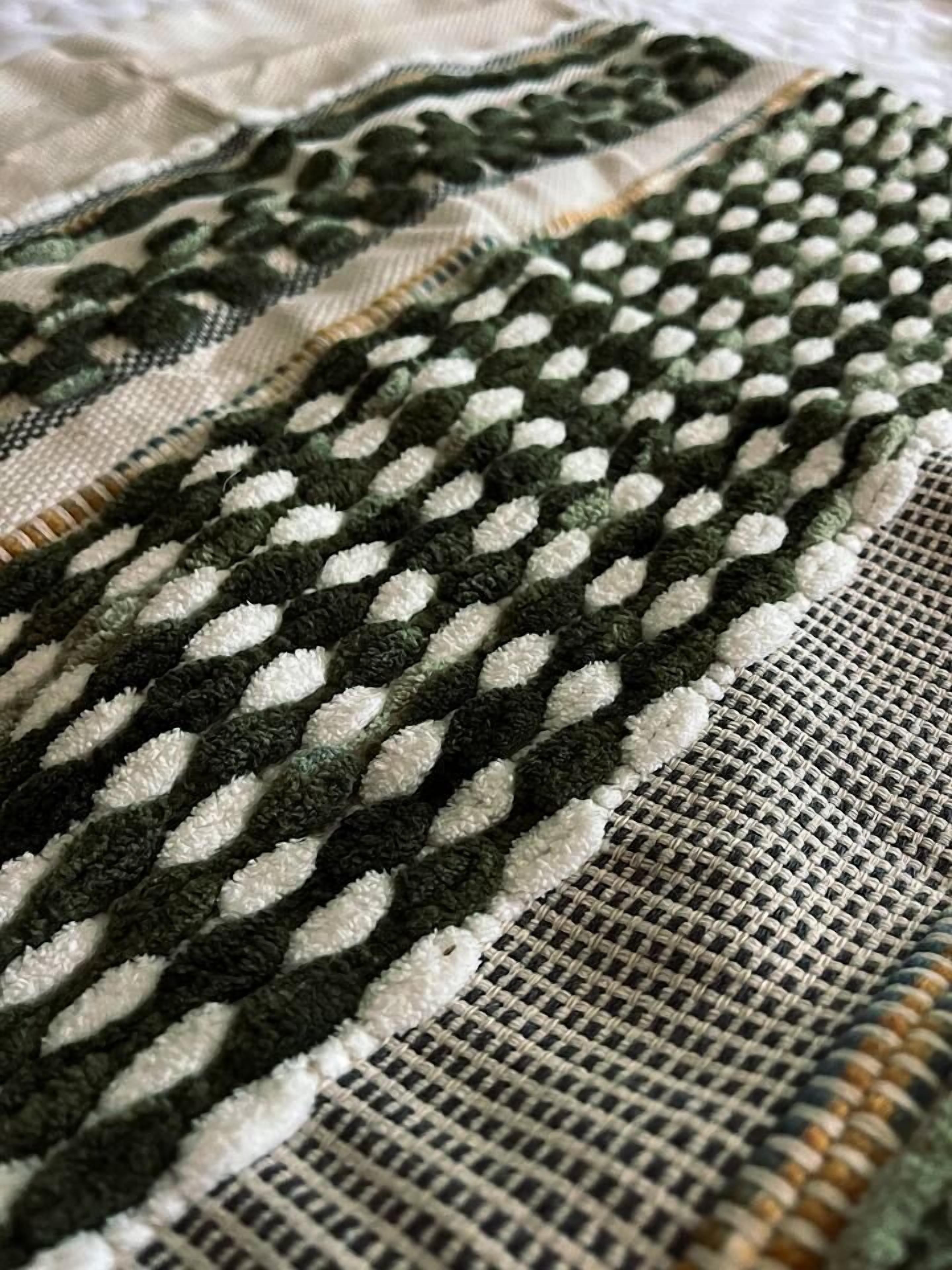A close-up of a textured fabric with a pattern of interwoven lines and shapes.