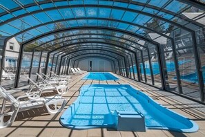Ein Poolbereich mit Liegestühlen und einem Sprungturm.