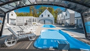A pool area with lounge chairs and a hot tub. - Comfortable holiday homes with SPA Rewal (Rewal)