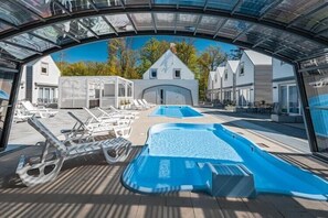 Ein Poolbereich mit Liegestühlen und einem Whirlpool.