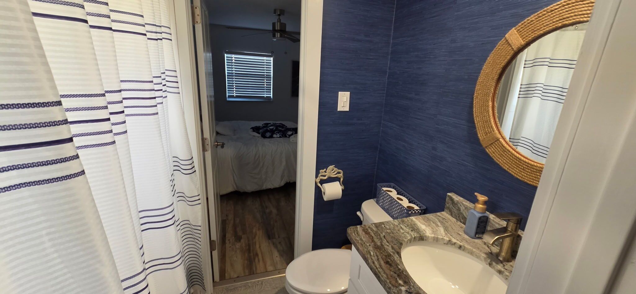 A bathroom with a toilet, sink, and shower curtain.