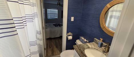 A bathroom with a toilet, sink, and shower curtain.