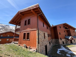 Un edificio in legno a più piani, con una base in pietra, ampie finestre e un balcone.