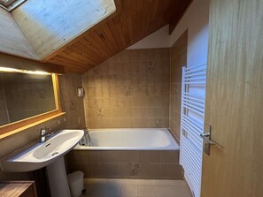 Ein Badezimmer mit Badewanne, Waschbecken und Spiegel.