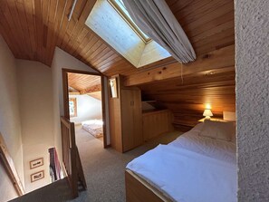 A cozy attic bedroom with a skylight, a bed, a desk, and a wardrobe. - Cozy apartment, pets welcome, near slopes - 5 guests (Méribel)