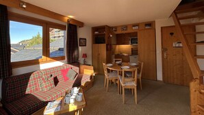 A cozy room with a sofa, dining table, and chairs, a kitchenette, and a window with a view. - Cozy apartment, pets welcome, near slopes - 5 guests (Méribel)