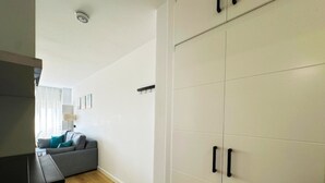 A modern living room with a grey sofa, a wooden floor, and a white wardrobe with black handles. - Central seaview studio with pool in Torremolinos (Torremolinos)