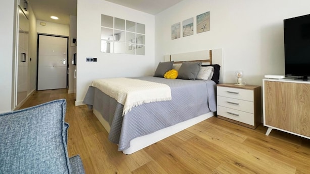 A bedroom with a bed, bedside table, TV, and a wardrobe. - Central seaview studio with pool in Torremolinos (Torremolinos)
