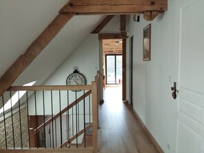 Eine Treppe mit Holzgeländern, die zu einem Zwischenpodest mit einer Uhr führt.