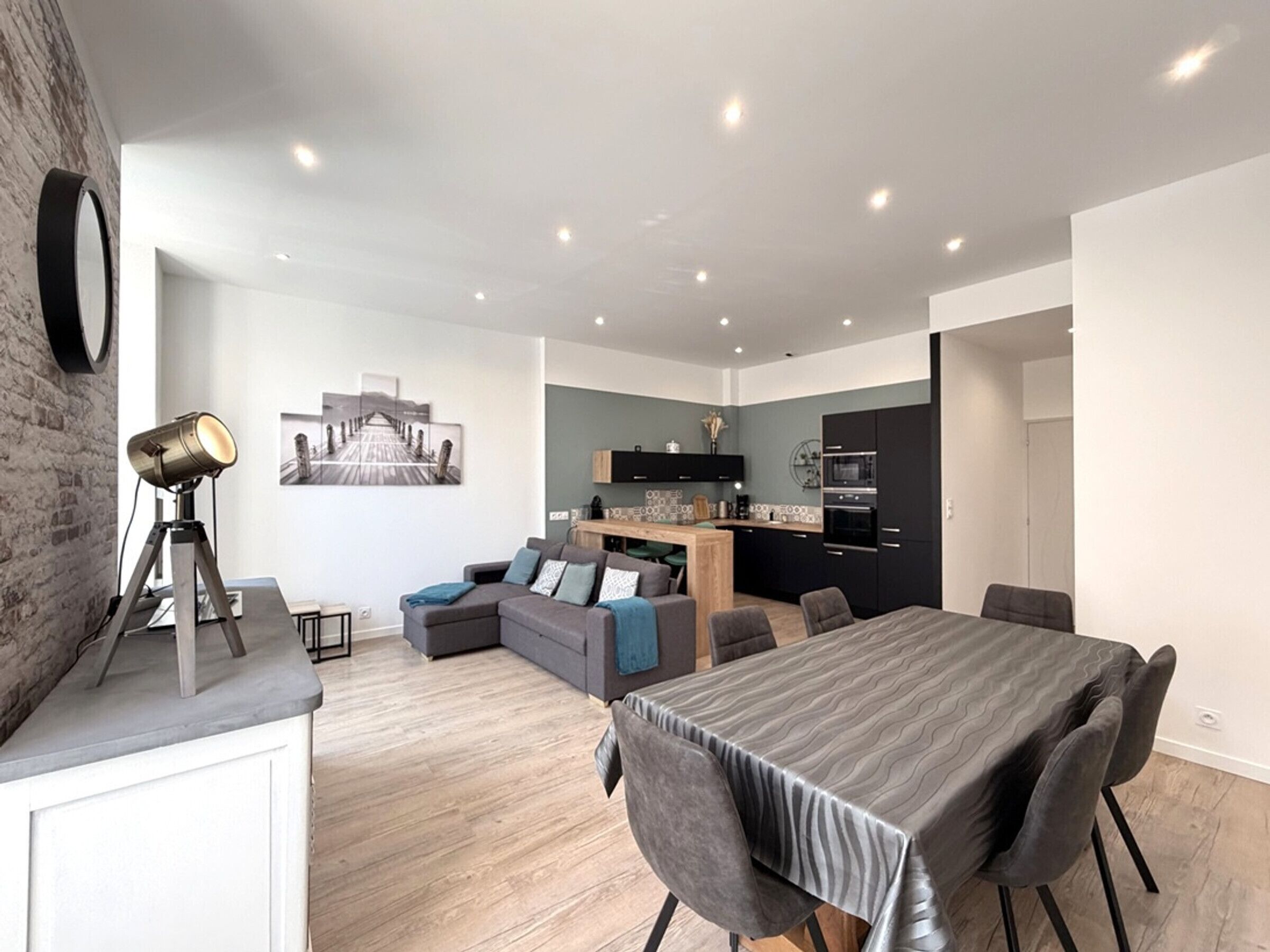 A modern apartment with a dining area, kitchen, and living space.