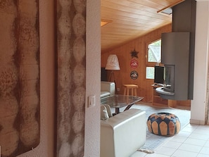Ein gemütliches Wohnzimmer mit einer Couch, einem Glastisch, einer Lampe und einem Fernseher.