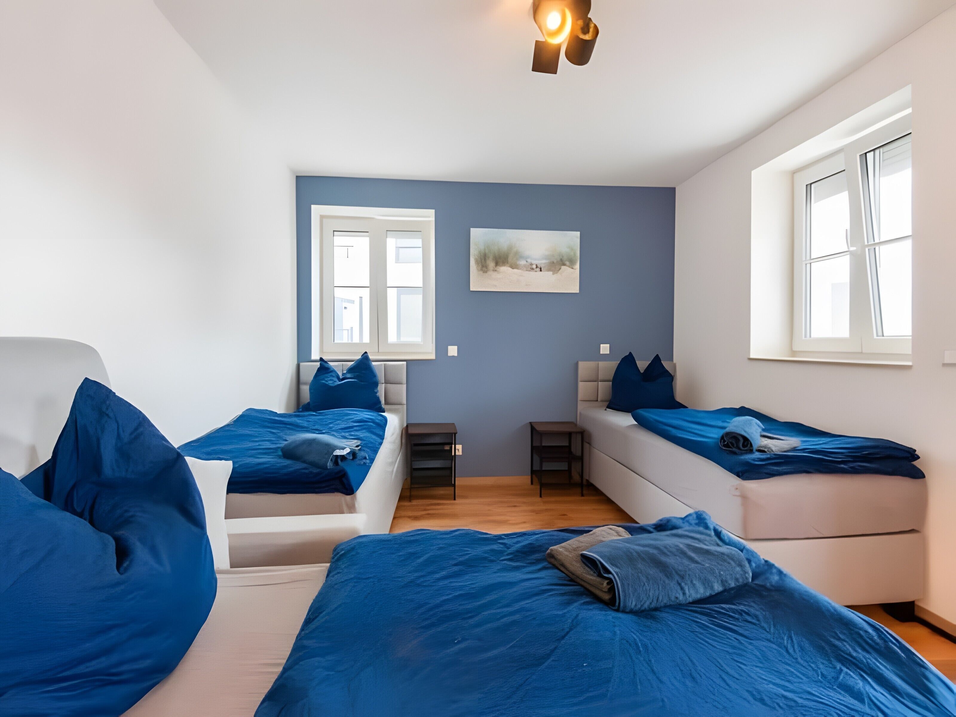 A room with two beds, a small table, and a window.