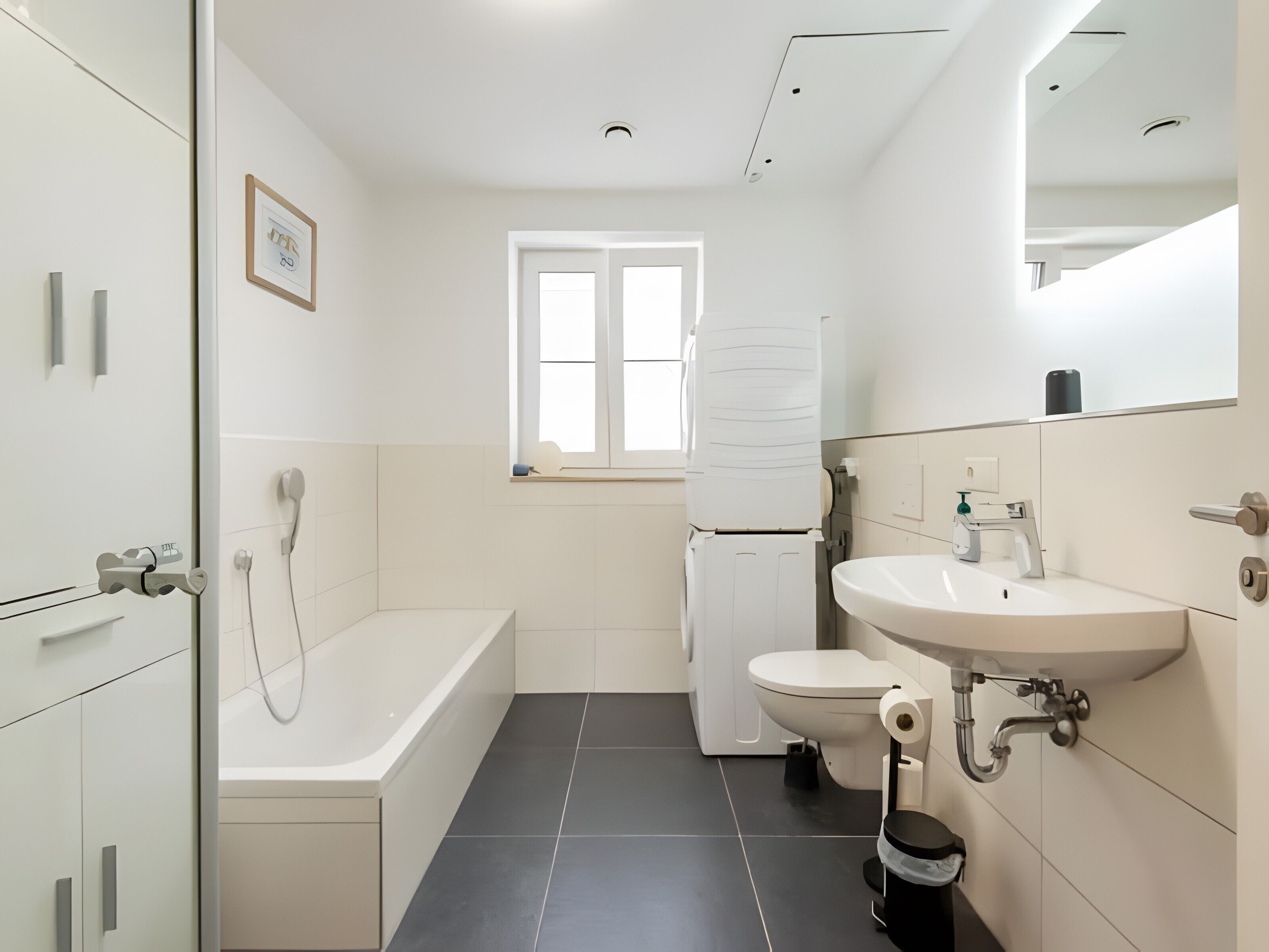 Et moderne badeværelse med badekar, toilet og håndvask.