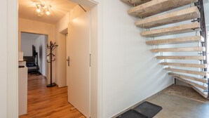 Una escalera de madera con barandilla metálica que conduce a un piso superior.