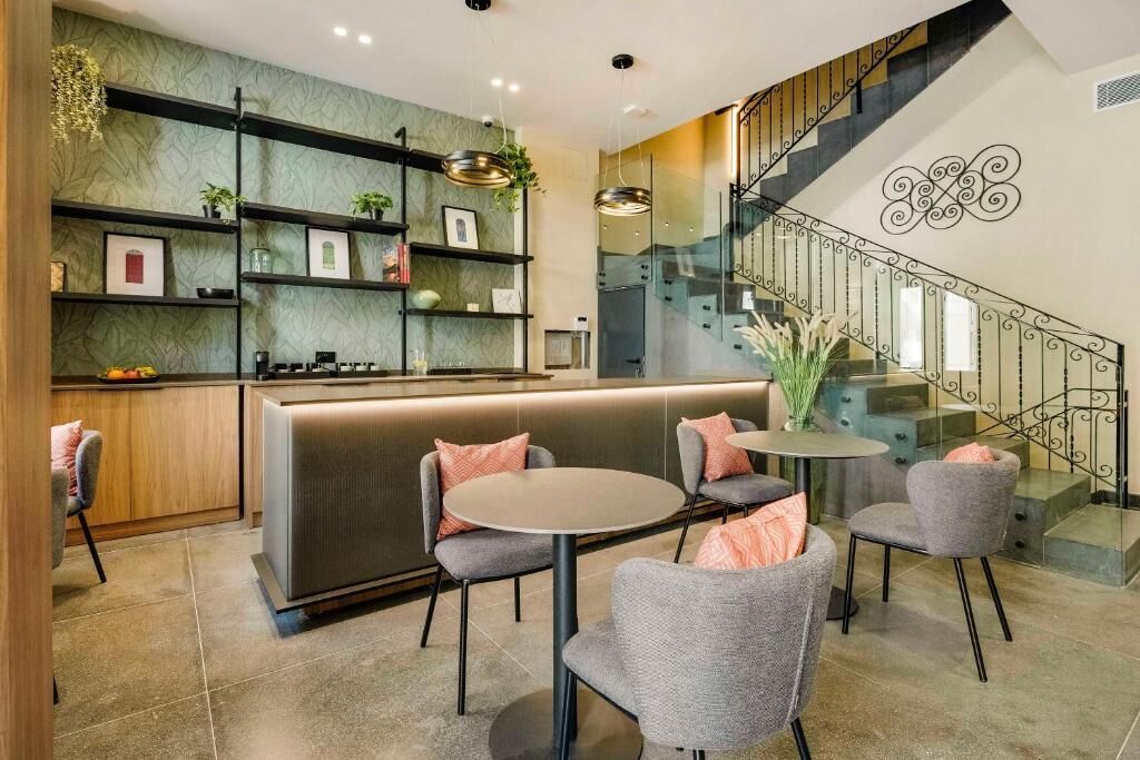 A modern interior with a bar area, seating, and a staircase.