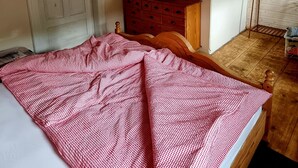 Une chambre à coucher avec un lit, une commode, un téléviseur et une fenêtre.