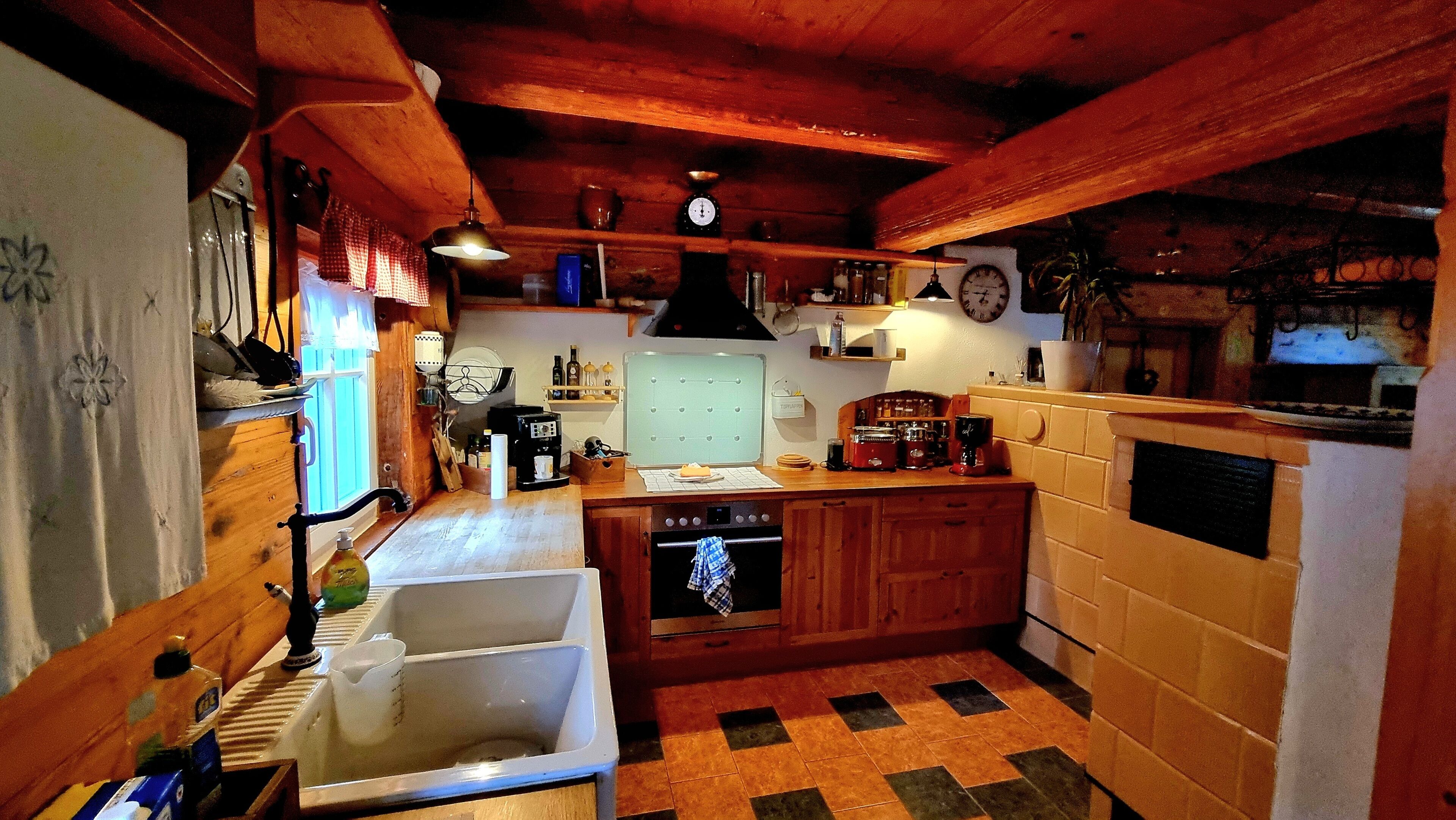 A kitchen with wooden cabinets, a sink, a stove, and various kitchen appliances.